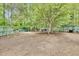 Large fenced backyard featuring mature trees, a playset, and plenty of space for outdoor activities at 4711 Buttonbush Dr, Durham, NC 27712