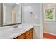 Bathroom with wooden vanity, white countertop, and decorative mirror at 4711 Buttonbush Dr, Durham, NC 27712