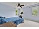 Spacious bedroom with a ceiling fan, two windows, and carpeted flooring for ultimate comfort at 4711 Buttonbush Dr, Durham, NC 27712