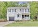 Charming two-story home with a garage, a front porch swing, and mature trees at 4711 Buttonbush Dr, Durham, NC 27712