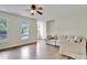 Sunlit living room featuring hardwood floors, a comfortable sofa, and large windows at 4711 Buttonbush Dr, Durham, NC 27712