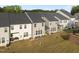 An aerial view shows a grassy backyard of townhomes, with patios perfect for outdoor relaxation at 484 Autumn Rain St, Cary, NC 27519