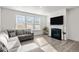 Bright living room boasts a fireplace, ample windows, and a comfortable sectional sofa at 484 Autumn Rain St, Cary, NC 27519