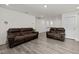 Spacious living room featuring two leather couches and vinyl plank flooring at 484 Autumn Rain St, Cary, NC 27519