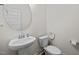 Clean powder room with pedestal sink, toilet, and round mirror, perfect for guests at 484 Autumn Rain St, Cary, NC 27519