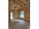 Unfinished room with framed walls, exposed ceiling, a door leading outside, and a window with natural light at 50 Watermelon Dr, Franklinton, NC 27525