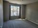 Bedroom with neutral walls, carpet, and a large window providing natural light at 5033 Amber Clay Ln, Raleigh, NC 27612