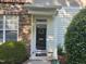 Inviting front entrance with stone accents, black front door, and a welcoming mat at 5033 Amber Clay Ln, Raleigh, NC 27612