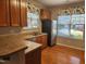 Well-lit kitchen with wood cabinets, stainless steel appliances, and hardwood floors at 5033 Amber Clay Ln, Raleigh, NC 27612