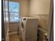 A dedicated laundry room area with machines, storage shelves, and a window at 5033 Amber Clay Ln, Raleigh, NC 27612