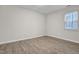 Empty bedroom features wood-look floors, base trim, and a window for natural light at 505 Gooseneck Dr # A1, Cary, NC 27513
