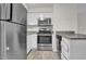 Galley kitchen features stainless appliances, granite countertops, and white cabinets at 505 Gooseneck Dr # A1, Cary, NC 27513