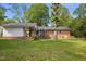 Spacious backyard featuring a well-maintained lawn, a covered porch, and mature shade trees at 515 Oakwood Ln, Graham, NC 27253