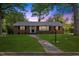 Charming brick home with a well-manicured lawn and inviting walkway, perfect for a Gathering at 515 Oakwood Ln, Graham, NC 27253