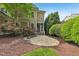 Backyard view showcasing stone patio, a screened-in porch, and vibrant landscaping at 528 Bankhead Dr, Cary, NC 27519