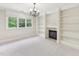 Sitting room featuring built-in bookshelves, fireplace, and large window at 528 Bankhead Dr, Cary, NC 27519