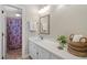 Clean bathroom with white vanity, decorative mirror, and colorful shower curtain at 5420 Royal Troon Dr, Raleigh, NC 27604
