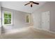 Spacious bedroom with neutral walls, bright windows, ceiling fan, and adjoining arched doorway at 5420 Royal Troon Dr, Raleigh, NC 27604