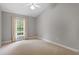 Cozy bedroom with carpet, a window with backyard view, and a ceiling fan at 5420 Royal Troon Dr, Raleigh, NC 27604