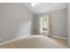 Bedroom with neutral carpet, a large window with treed view and privacy curtains at 5420 Royal Troon Dr, Raleigh, NC 27604
