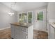 Bright kitchen featuring a white island with granite countertop and a window with backyard view at 5420 Royal Troon Dr, Raleigh, NC 27604