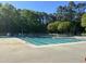 Community swimming pool surrounded by mature trees and a white picket fence for a serene, safe outdoor experience at 5420 Royal Troon Dr, Raleigh, NC 27604