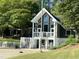 Two story pool house with large windows, white railings, a white picket fence, and adjacent patio at 5420 Royal Troon Dr, Raleigh, NC 27604