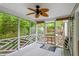 Screened porch with wicker ceiling fan and seating area with views of the yard at 5420 Royal Troon Dr, Raleigh, NC 27604