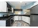 Well-lit kitchen featuring stainless steel appliances, white cabinets and a view to the stairs at 6011 Winterpointe Ln # 205, Raleigh, NC 27606