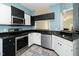 Charming kitchen featuring black countertops, stainless steel appliances and a stylish tiled floor at 6011 Winterpointe Ln # 205, Raleigh, NC 27606