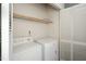 Convenient laundry closet with white washer, dryer, shelving, and bi-fold doors at 6011 Winterpointe Ln # 205, Raleigh, NC 27606