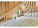 Spacious unfinished attic with exposed wooden beams and a window, providing an opportunity for customization and expansion at 669 Balmoral St, Clayton, NC 27520