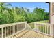 Back deck with white railing overlooking a large green yard with mature trees, offering a private outdoor space at 669 Balmoral St, Clayton, NC 27520
