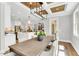 Elegant dining area with a long wooden table, chandelier lighting, and open kitchen view at 669 Balmoral St, Clayton, NC 27520