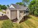 Rear exterior view of a home with a screened-in porch and backyard, accentuating its architectural design and outdoor amenities at 669 Balmoral St, Clayton, NC 27520