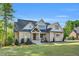 Elegant two-story home with stone accents, gabled roof, and a lush green lawn at 669 Balmoral St, Clayton, NC 27520