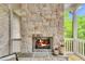 Stone fireplace on an enclosed porch with views of the outdoors and a slate hearth at 669 Balmoral St, Clayton, NC 27520