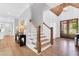 Welcoming foyer with hardwood floors, staircase, wainscoting, and a decorative table leading to the front entrance at 669 Balmoral St, Clayton, NC 27520