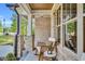 Inviting front porch with rocking chairs, stone accents, wood ceiling, and large windows, offering a cozy outdoor space at 669 Balmoral St, Clayton, NC 27520