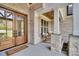 Charming front porch featuring stone columns, rocking chairs, and a wood-framed front door with glass panels at 669 Balmoral St, Clayton, NC 27520