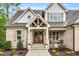 Inviting front porch featuring a gable roof, stone columns, and cozy rocking chairs at 669 Balmoral St, Clayton, NC 27520