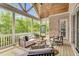 Inviting screened porch with wood ceiling, comfortable seating, and a view of the wooded backyard at 669 Balmoral St, Clayton, NC 27520