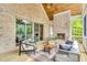 Inviting screened porch with a stone fireplace, wood ceiling, and comfortable furnishings at 669 Balmoral St, Clayton, NC 27520