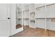 Bright walk-in closet with custom shelving, a full-length mirror, and hardwood flooring at 669 Balmoral St, Clayton, NC 27520