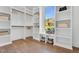 Spacious walk-in closet with custom shelving, a window seat with backyard views, and wood flooring at 669 Balmoral St, Clayton, NC 27520