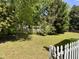 Spacious backyard featuring a well-maintained lawn, mature trees, and a classic picket fence at 6715 St Johns Ct, Raleigh, NC 27616