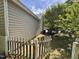 Side view of the home with a wooden fence and a tree at 6715 St Johns Ct, Raleigh, NC 27616