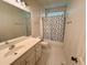 Well-lit bathroom with a tub and shower combination, white vanity, and classic fixtures at 6715 St Johns Ct, Raleigh, NC 27616