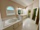 Large bathroom with tub, double sinks, tile floors and walk-in closet at 6715 St Johns Ct, Raleigh, NC 27616