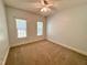 Cozy bedroom with carpeted floors, two windows, and a ceiling fan at 6715 St Johns Ct, Raleigh, NC 27616